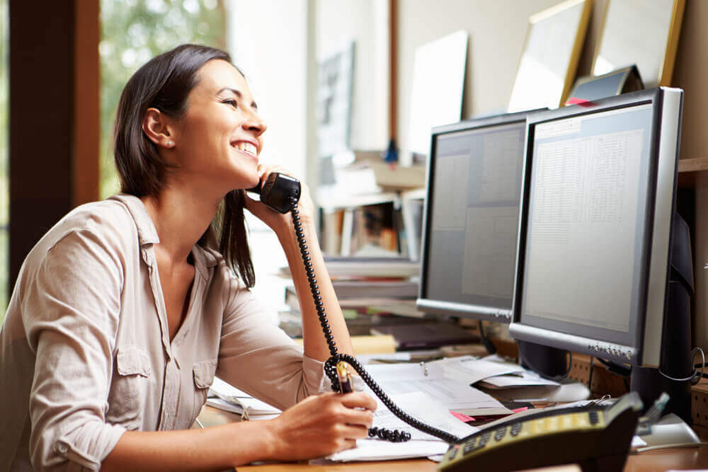 Smiling female property manager talking to a prospective tenant on the phone