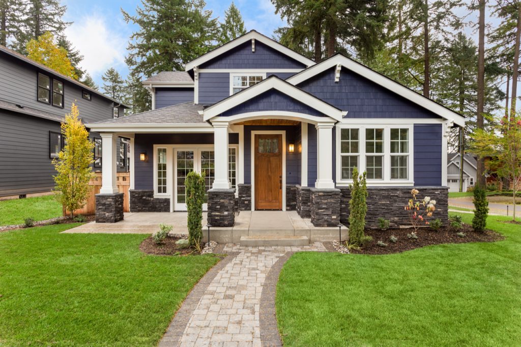 grey rental house with white pillars and window trim