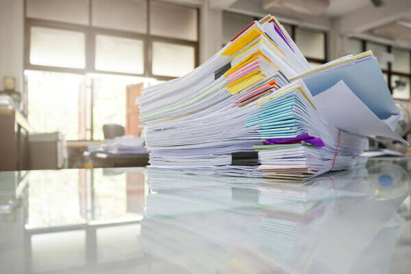 A stack of LLC Paperwork sitting on a white desk